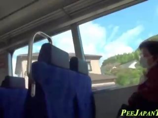Asian peeing on train